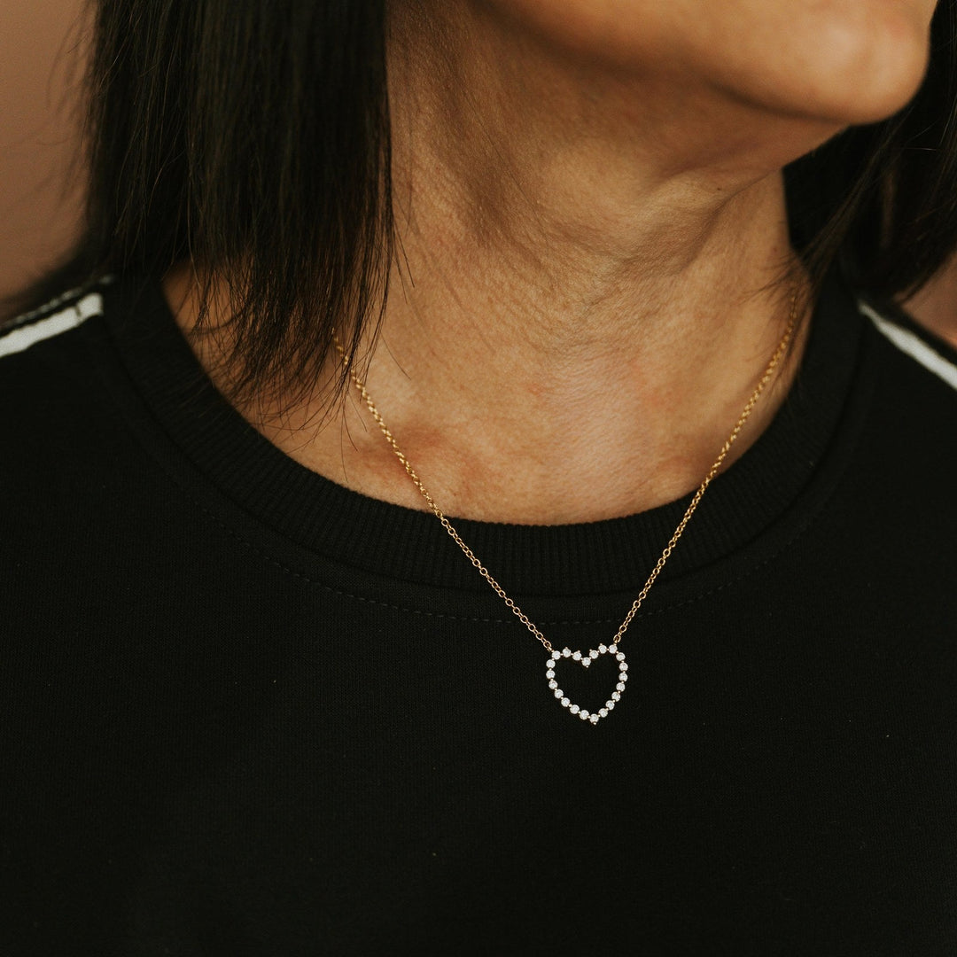 Jessica Signature Heart Pendant Necklace in gold with sparkling stones, worn with a black top